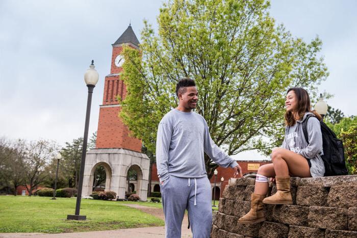 Two students talking in an outside space of the East Texas A&M campus at Navarro College.